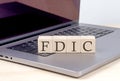 FDIC word on wooden block on laptop, business concept Royalty Free Stock Photo