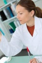 Feamle chemist smiling while hold test pipette in lab