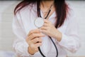 Feamle doctor with stethoscope examining red heart Royalty Free Stock Photo