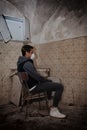 Fear of Coronavirus Codiv-19, a man sitting on a chair in a old ruin, symbol of loneliness and fear of epidemic illness in Italy