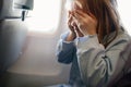 fear of flying. a kid girl closes her eyes with her hands in the airplane seat Royalty Free Stock Photo