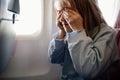 fear of flying. a kid girl closes her eyes with her hands in the airplane seat Royalty Free Stock Photo