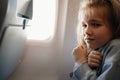 fear of flying. a kid girl trembles with fear in the airplane seat Royalty Free Stock Photo