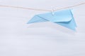 Fear of flying, plane crash or aerophobia concept. Blue paper plane upside down, plane hanging on a thread Royalty Free Stock Photo