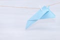 Fear of flying, plane crash or aerophobia concept. Blue paper plane upside down, plane hanging on a thread Royalty Free Stock Photo