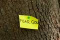 Fear God, a handwritten Bible verse on a note pinned on a tree in nature