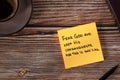 Fear God and keep His commandments, handwritten verse on yellow note with bible book and coffee cup on wooden table, top view