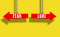 Fear or love choice . Red arrow hanged with metal chain. fear vs love concept. yellow background Royalty Free Stock Photo