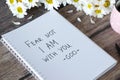 Fear not I am with you, God, handwritten text in notebook with flowers and cup of coffee on wooden table