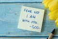 Fear not I Am with you, God. Handwritten verse quote with pen and yellow tulips on wood