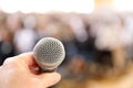 Fear of public speaking. A very close microphone in front of a blurred crowd