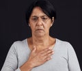 Fear, senior and a woman with a heart attack on a black background with healthcare anxiety. Emergency, sad and an Royalty Free Stock Photo