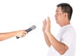 Fear to speak concept. Man show his hand to avoid microphone in studio. Isolated on white Royalty Free Stock Photo