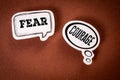 Fear vs Courage Concept with Thought Bubbles on Brown Background Royalty Free Stock Photo