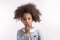 Fearful african girl closing her mouth with a hand Royalty Free Stock Photo