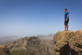 Fearless hiker looking at horizon from top of cliff edge in Roque Nublo