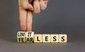 Fearless and limitless symbol. Concept word Fearless and limitless on wooden cubes. Businessman hand. Beautiful grey table grey