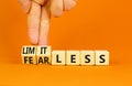 Fearless and limitless symbol. Concept word Fearless and limitless on wooden cubes. Businessman hand. Beautiful orange table Royalty Free Stock Photo