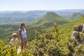 fearless woman with adorable happy boy stand on the steep edge of limestone plateau overlooking the valley