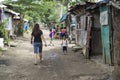 Fearless Young lady walking along on a slum rough road street unaccompanied