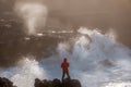Fearless young photographer surrounded by raging waves at rocky Oregon coast
