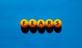 Fears symbol. The concept word `fears` on orange table tennis balls. Beautiful blue table, blue background, copy space. Business