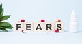Fears word made with building blocks. A row of wooden cubes with a word written in black font is located on white background