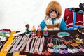 Feast of reindeer herders and fishermans. A woman in national costume sells traditional souvenirs of the North