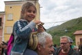 The feast of Serpari in the center of Cocullo medieval village. Portrait of happy little girl with snake, Abruzzo, Italy