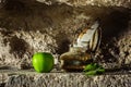 Feather in antique ink bottle and an apple in sandstone cave background Royalty Free Stock Photo