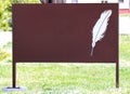Feather on blank brown sign.