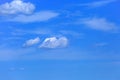 Feather and Cumulus clouds in a blue sky Royalty Free Stock Photo