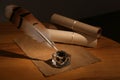 Feather pen, inkwell and blank parchment on table