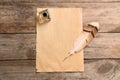 Feather pen, inkwell and blank parchment on wooden table, top view Royalty Free Stock Photo