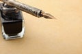 Feather quill and inkwell on an old paper Royalty Free Stock Photo