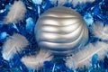 Feather and silvery Christmas ball on a blue tinsel Royalty Free Stock Photo