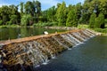 Feathered ducks swim in the lake with a decorative stone cascading waterfall. Royalty Free Stock Photo