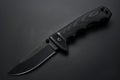 Featuring a black combat knife on black background, top view. high resolution photo Royalty Free Stock Photo