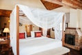 Asian tropical bedroom four poster bed white curtain and fireplace