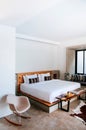 White contemporary hotel style bedroom with white linen high ceilling and vintage floor fan