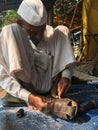 Skilled hands using needal & working on roadside shoe repairer in Kalyan