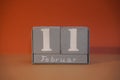 11 Februar on wooden grey cubes. Calendar cube date 11 February. Concept of date. Copy space for text. Educational cubes