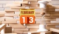 13 Februar on wooden grey cubes. Calendar cube date 13 February. Concept of date