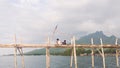 February 2023, Bletok Beach Situbondo - little kids fishing on the sea bridge with mountains in the background