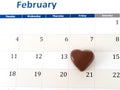 February calendar page with a heart chocolate marking valentines day