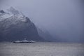 Storfjorden, Norway - February 2, 2024: A car ferry sails between the mountains during storm Ingunn Royalty Free Stock Photo