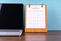 February 2024 desk calendar and laptop