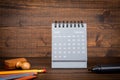 2023 February. Desk calendar and office supplies on wooden texture background