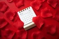 February 2024 desk calendar and pink rose petals on a red background Royalty Free Stock Photo