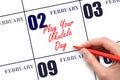 February 2. Hand writing text Play Your Ukulele Day on calendar date. Save the date.